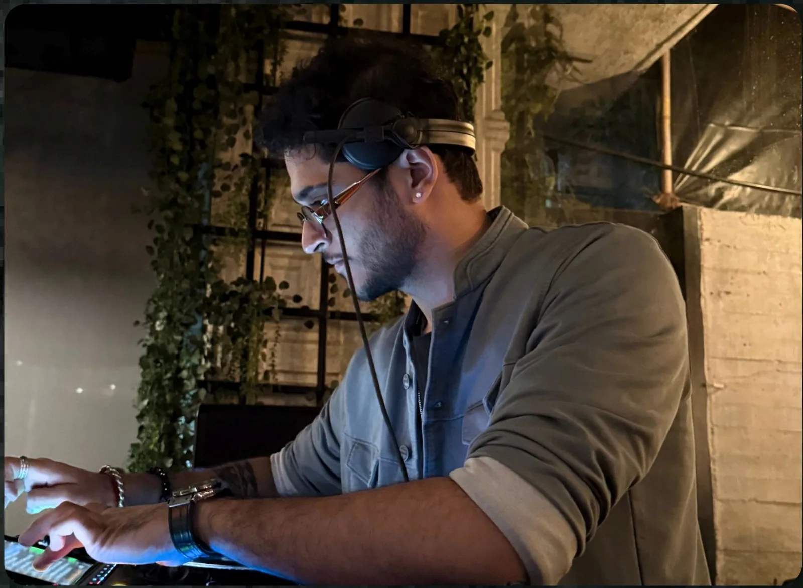 SHIKO wearing headphones while working on a DJ controller